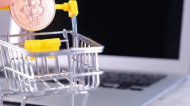 Şifreli çevrimiçi alışveriş konsepti, alış veriş arabası dizüstü bilgisayarında kripto para. Elektronik sanal para. Kadın el atölye arabasına bozuk para koyar.