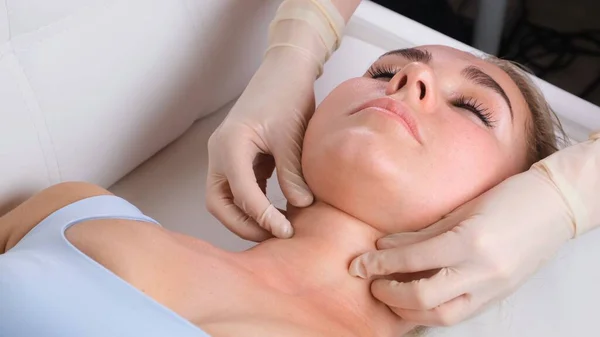 Massage du menton de femme jeune femme pendant le massage du visage au salon de beauté — Photo