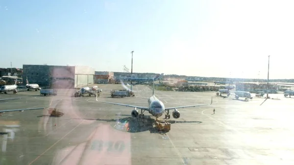 Parked plane at the airport of Moscow through the gate window. Maintenance and preparation of the aircraft for the regiment: Moscow, Russia - June 28, 2021. — Stock Photo, Image