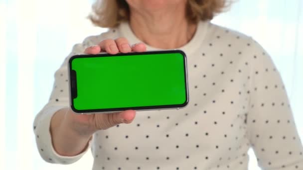 Середньолітня жінка-сенора використовує смартфон iPhone з хроматичним екраном ключа, копіюванням простору, закриттям. Концепція онлайн-шопінгу, використання мобільних додатків: Москва, Росія - 24 червня 2021. — стокове відео