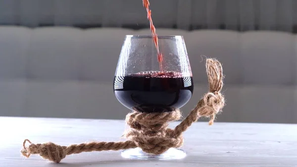 El vino se vierte en vidrio se ata con una cuerda. El concepto de dependencia del alcohol. — Foto de Stock