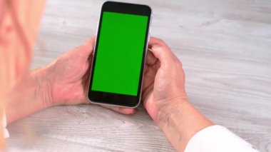 Orta yaşlı bayan sinyora krom ekranlı iPhone akıllı telefonu kullanıyor, kopyalama alanı. Çevrimiçi alışveriş kavramı, mobil uygulamaların kullanımı: Moskova, Rusya - 24 Haziran 2021.