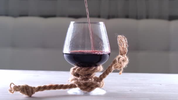 Vin hälls i glas är bunden med ett rep. Begreppet alkoholberoende. — Stockvideo
