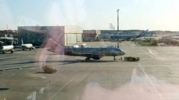 Geparktes Flugzeug auf dem Moskauer Flughafen durch das Gate-Fenster. Wartung und Vorbereitung der Flugzeuge für das Regiment: Moskau, Russland - 28. Juni 2021. — Stockfoto