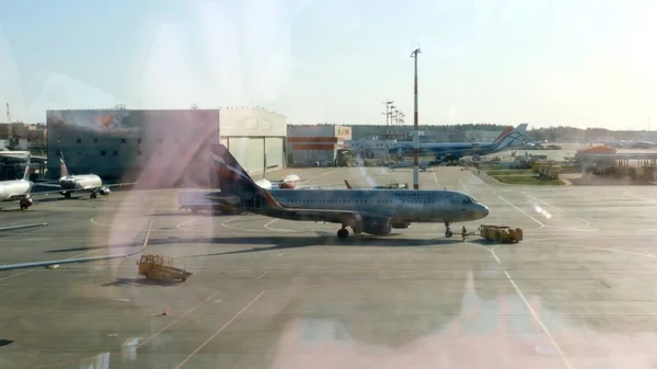 Geparktes Flugzeug auf dem Moskauer Flughafen durch das Gate-Fenster. Wartung und Vorbereitung der Flugzeuge für das Regiment: Moskau, Russland - 28. Juni 2021. — Stockfoto