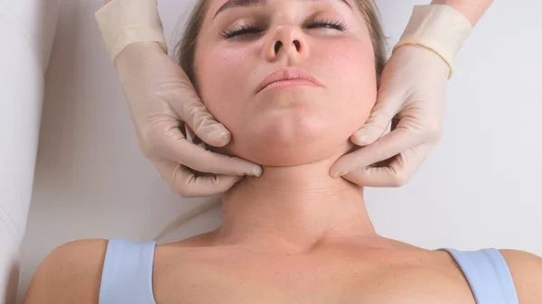 Massage du menton de femme jeune femme pendant le massage du visage au salon de beauté — Photo