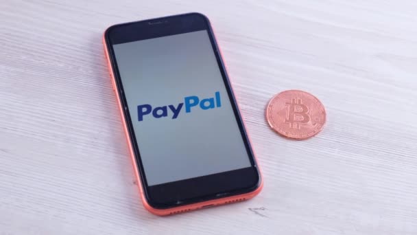 Logotipo de PayPal en el teléfono inteligente de la pantalla con criptomoneda bitcoin: Moscú, Rusia - 31 de mayo de 2021 — Vídeos de Stock