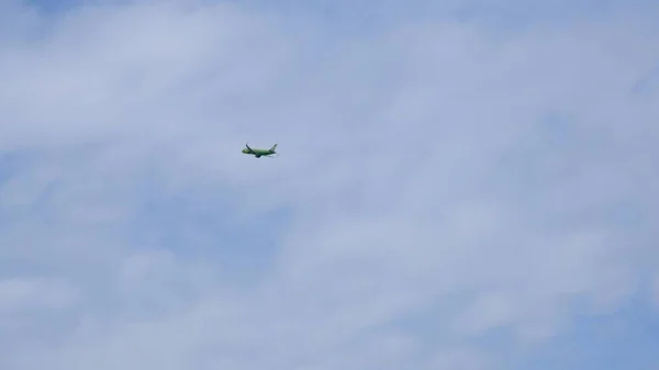 Silhouette Modernes Großflugzeug fliegt am Himmel. Schöner blauer Himmel und weiße Wolken im Hintergrund. Das Flugzeug fliegt über Kopf. Flugzeug startet oder landet — Stockfoto