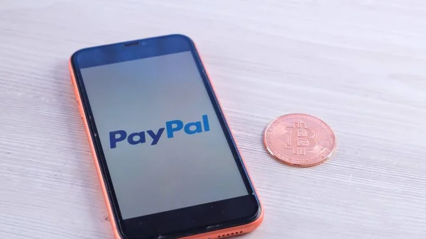 Logotipo de PayPal en el teléfono inteligente de la pantalla con criptomoneda bitcoin: Moscú, Rusia - 31 de mayo de 2021 —  Fotos de Stock