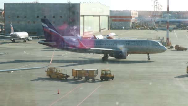 Aereo parcheggiato all'aeroporto di Mosca attraverso la finestra del cancello. Manutenzione e preparazione dell'aeromobile per il reggimento: Mosca, Russia - 28 giugno 2021. — Video Stock