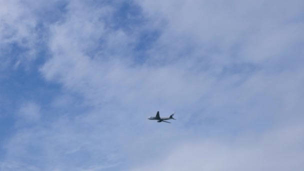 Современный большой самолет летает в небе. Красивое голубое небо и белые облака на заднем плане. Самолет пролетает над головой. Самолет взлетает или садится — стоковое видео