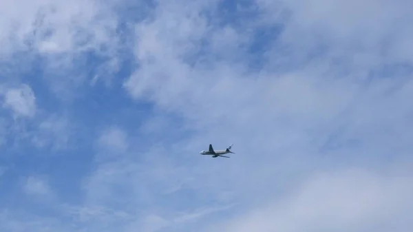 Sylwetka Nowoczesny duży samolot lata po niebie. Piękne błękitne niebo i białe chmury w tle. Samolot leci nad głową. Samolot startuje lub ląduje — Zdjęcie stockowe