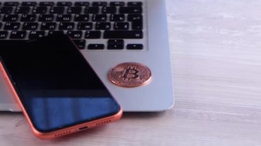 Bilgisayarı ve akıllı telefonu olan altın para masanın üstünde. Crypto, engelleme ağı içindeki Dijital Para, teknoloji ve çevrimiçi internet değiş tokuşu kullanılarak takas ediliyor. Mali konsept