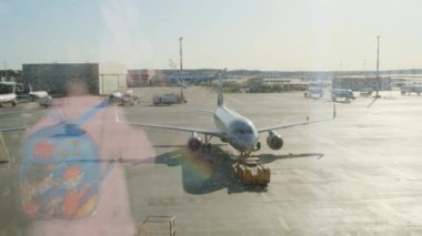 Küçük kız Moskova Havaalanı 'ndaki park uçağını kapı penceresinden izliyor. Alay için uçağın bakımı ve hazırlığı. Tatil, seyahat, beklentiler ve hayaller kavramı: Moskova