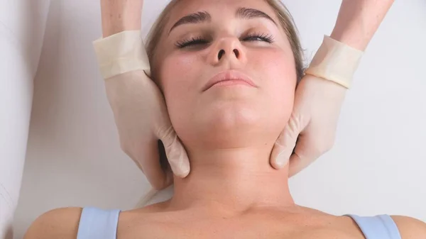 Massagem de queixo de mulher jovem durante a massagem facial no salão de beleza — Fotografia de Stock
