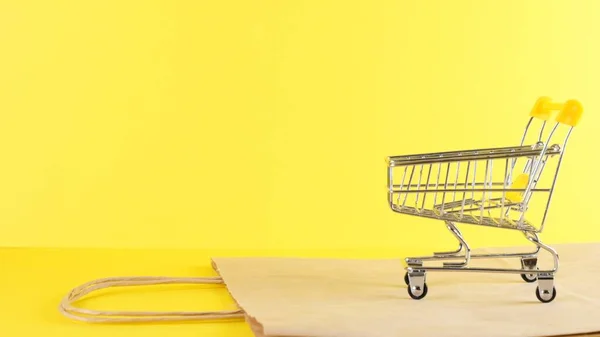 Vacío carrito de compras sobre un fondo amarillo, primer plano. Viernes Negro Compras y descuento Concepto — Foto de Stock