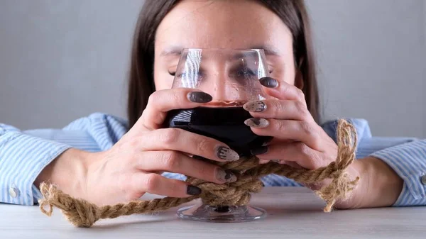 Triste fêmea olhando copo de vinho amarrado com corda de juta. O conceito de dependência de álcool. O problema do tratamento do alcoolismo — Fotografia de Stock