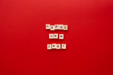 Kelime Mutlu Yeni Yıl Kırmızı arkaplandaki ahşap harflerden yapılmıştır Kopya alanı ile
