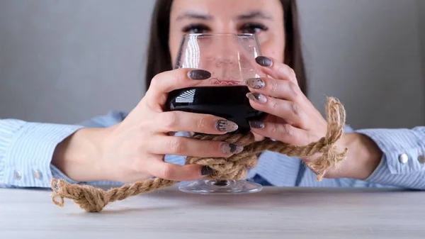 Triste fêmea olhando copo de vinho amarrado com corda de juta. O conceito de dependência de álcool. O problema do tratamento do alcoolismo — Fotografia de Stock