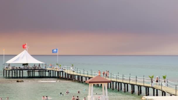 Rök från skogsbränder stiger över en strand i Antalya, Manavgat semesterort Turkiet. Visa med människor på stranden: Antalya, Manavgat Turkiet - 28 juli 2021. — Stockvideo