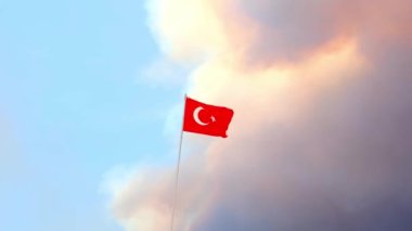 Orman yangını duman bulutlarından oluşan bir arka planda Türkiye bayrağı yaklaştı. Seçici odak.