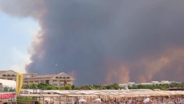 Chamas e fumaça de incêndios florestais cobrem a paisagem. Nuvens de fumaça sobre hotéis e sobre o mar: Antalya, Manavgat Turquia - 28 de julho de 2021. — Vídeo de Stock