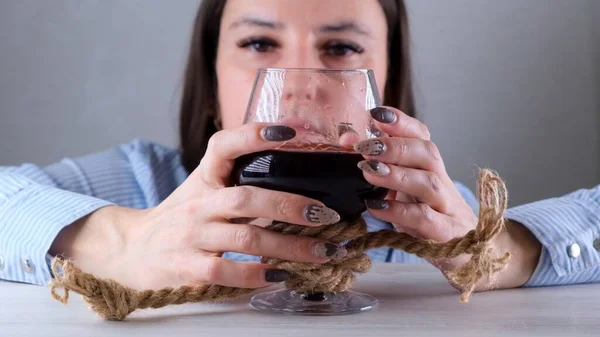 Θλιβερό ποτήρι κρασιού δεμένο με σχοινί γιούτας. Η έννοια του εθισμού στο αλκοόλ. Το πρόβλημα της θεραπείας του αλκοολισμού — Φωτογραφία Αρχείου