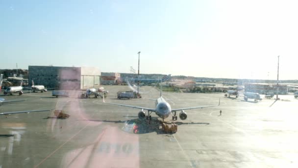 Avión estacionado en el aeropuerto de Moscú a través de la ventana de la puerta. Mantenimiento y preparación del avión para el regimiento: Moscú, Rusia - 28 de junio de 2021. — Vídeos de Stock