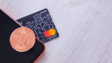 Bitcoin altın sikke ve modern bir akıllı telefon ekranının üzerinde duran bir kredi kartı. BTC engelleme zinciri ödemeleri, taşınabilir depolama ve ödeme, şifreli para birimi soyut kavramı ile ödeme: