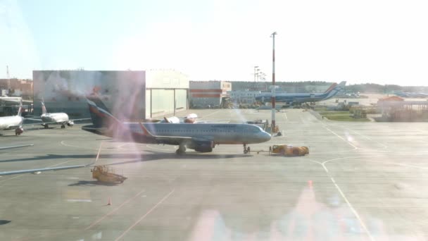 Zaparkované letadlo na letišti v Moskvě oknem u brány. Údržba a příprava letadel pro pluk: Moskva, Rusko - 28. června 2021. — Stock video
