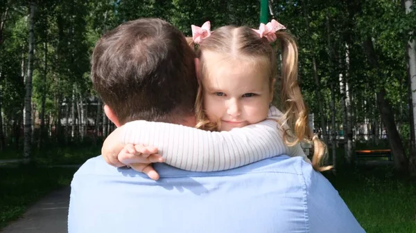 Buon padre che si porta al collo e abbraccia la figlia di 4-5 anni mentre cammina nel parco — Foto Stock