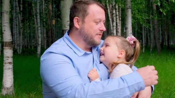 Portré egy pár ölelkező boldog apa és lánya 3-4 éves séta közben a parkban — Stock videók