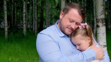 Gülümseyen baba, 3 yaşındaki kızını nazikçe öpüyor ve sarılıyor. Babalığın tadını çıkarıyor. Babalar Günü. Mutlu çocukluk ve ebeveynlik kavramları. Çocuk koruması
