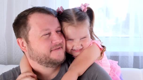 Portrait of joyful dad and daughter, 3 years old, playing at home. Fathers day. Handsome young man at home with his little cute girl are having fun together. Fatherhood concept, happy childhood — Stock Video