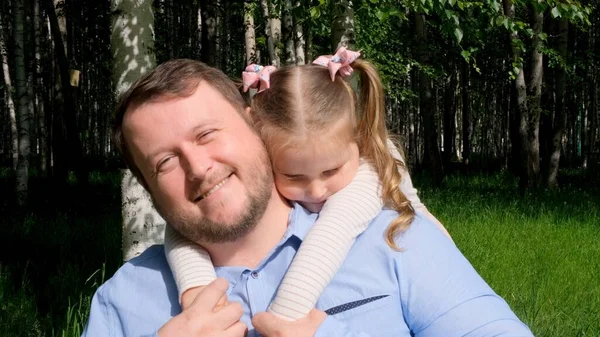 O pai sorridente abraça suavemente sua filhinha, de 3 anos, desfrutando da paternidade. Dia dos pais. Infância feliz e conceito de paternidade — Fotografia de Stock