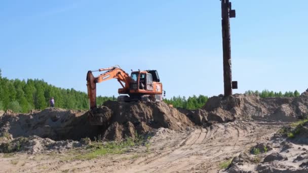 Gula bulldozern utför jordarbeten genom att gräva sand på en byggarbetsplats: Moskva, Ryssland - 30 augusti 2021. — Stockvideo