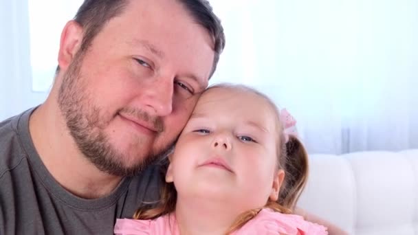 Lilla dottern 3 år gammal och far kramas försiktigt och ha kul hemma. Ha kul med ditt barn, dumskalle. Pappadagen. föräldraskap, relationer mellan barn och föräldrar — Stockvideo