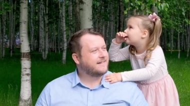 Üç yaşında neşeli küçük bir kızı var. Kulağına fısıldayıp gülüyor. Mutlu bir çocukluk, babalık, ebeveynlik kavramı. Ebeveynler ve çocuklar arasındaki güven ilişkisi. Babalar Günü