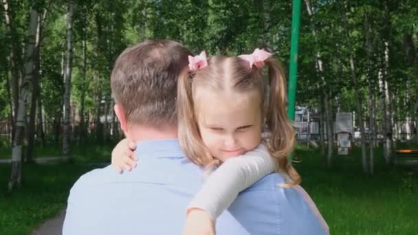 Der starke Vater hält eine süße Tochter, 3 Jahre alt, auf dem Arm, umarmt sie und umarmt sie. Das Konzept der Elternschaft, die Überwindung von Problemen in der Beziehung zwischen Vater und Tochter, Krankheit, Angst um — Stockvideo