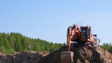 Sarı kazıcı buldozer, 30 Ağustos 2021 'de Moskova, Rusya' da bir inşaat sahasında kum kazarak toprak çalışmalarını gerçekleştirir..