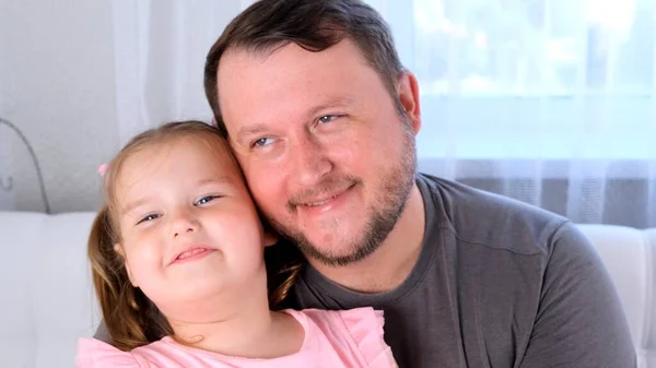 Lilla dottern 3 år gammal och far kramas försiktigt och ha kul hemma. Ha kul med ditt barn, dumskalle. Pappadagen. föräldraskap, relationer mellan barn och föräldrar — Stockfoto