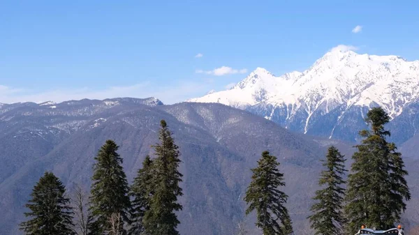 Schilderachtige landschap van besneeuwde bergen met witte wolken op een blauwe hemel op een zonnige dag in Krasnaya Polyana in Sochi, Rusland — Stockfoto