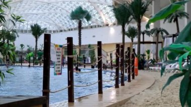 Kapalı bir yerde mavi suyu ve gerçek kumu olan lüks bir yüzme havuzu. Yaz tatili ve dinlenme, seyahat, yüzme eğitimi kavramı: Sochi, Rusya - 17 Mayıs 2021.