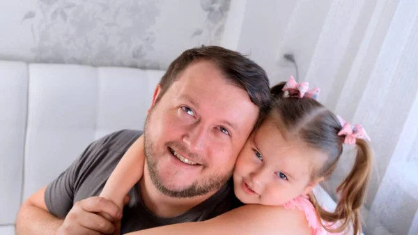 Retrato de pai e filha sorridentes, 3 anos, brincando em casa. Dia dos pais. Bonito jovem em casa com sua menina bonitinha estão se divertindo juntos. Conceito de paternidade, infância feliz — Fotografia de Stock