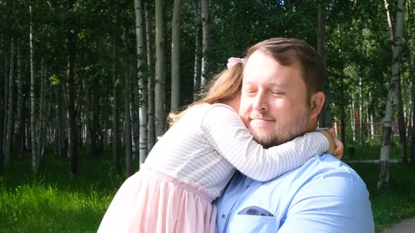 公園を歩いている間に彼の首と抱きかかえている娘4-5歳の幸せな父親 — ストック写真
