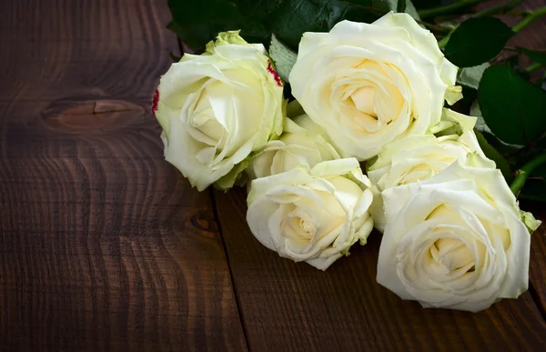 Rosas largas na mesa de madeira — Fotografia de Stock