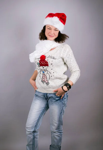 可愛いです若いです女性身に着けているサンタ帽子とセーターとともに雪だるまの形 — ストック写真