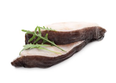 Beyaz arka planda iki balık bifteği ve roka yaprakları.