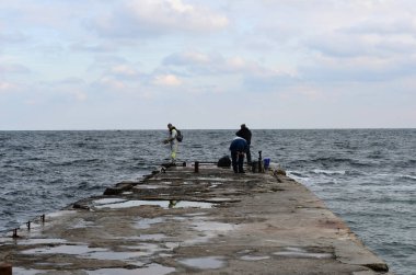 Mızraklı balıkçılar oltayla balık yakalar..