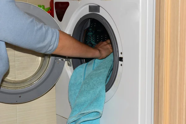 A woman is laying underwear for washing in the washing machine. High quality photo